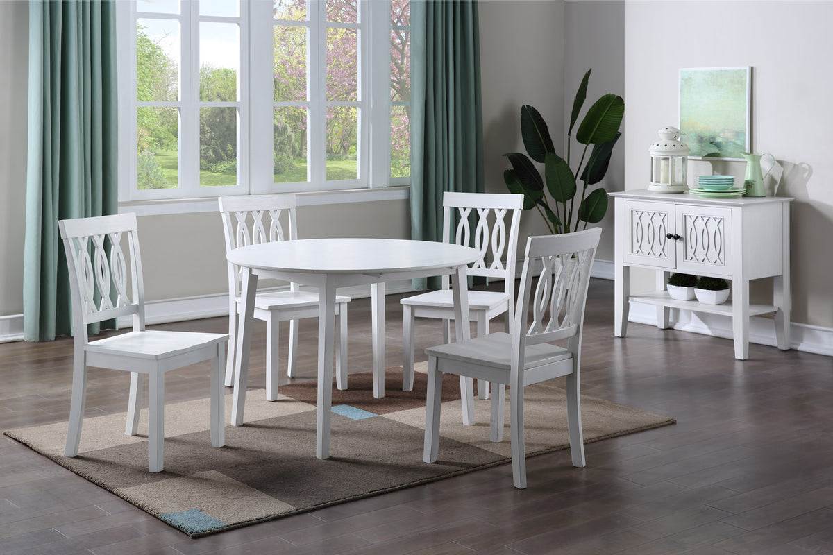 White round dining table with four matching chairs and a sideboard in the background